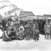 Cover image of Ben and Janet Kaquitts standing on the left in regalia, Mark Poucette standing to the right in regalia, Stoney Nakoda
